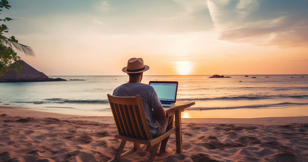Personne travaillant sur un ordinateur portable face à un coucher de soleil symbolisant la liberté financière et les revenus passifs sans échange de temps contre argent